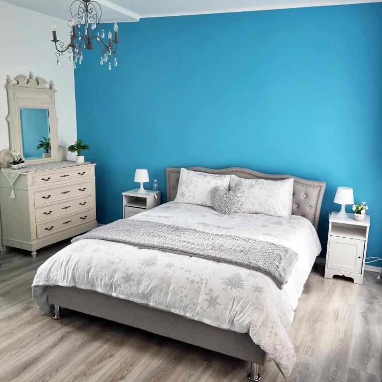 - une chambre bleue avec un lit et un mur bleu dans l'établissement Les Suites de la Bastide, à Carcassonne
