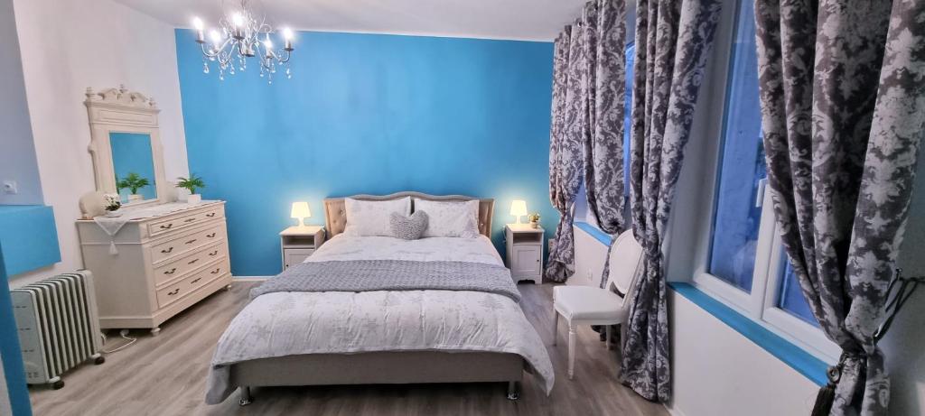Dormitorio azul con cama y pared azul en La Marquise en Carcassonne
