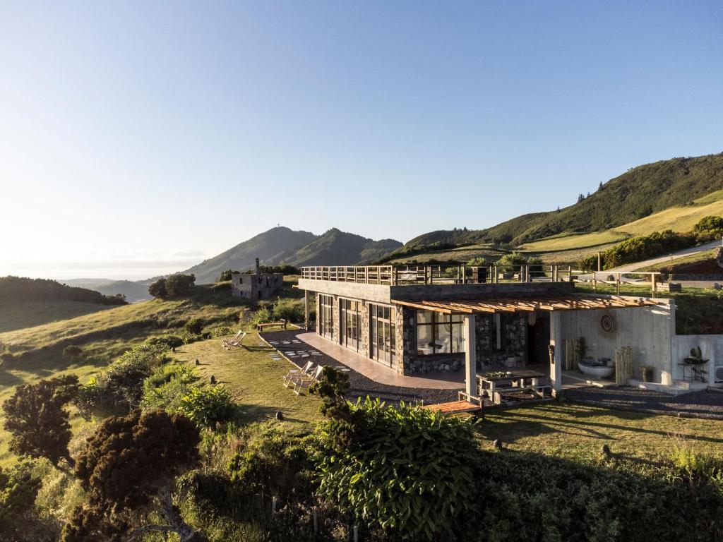 a house on a hill with a view of the ocean at Villa - Cantinho do Paraíso in Santo Espírito