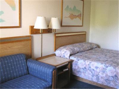 a hotel room with a bed and a chair at Colorado River Value Inn in Bullhead City