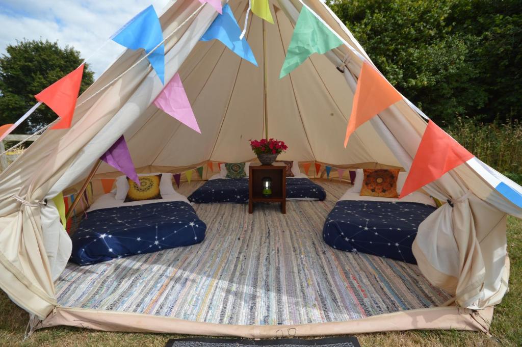 a tent with couches and a table in a field at Starlight Glamping 