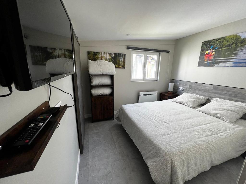 a bedroom with a bed and a television in it at Les Cygnes au bord du loing in Montigny-sur-Loing