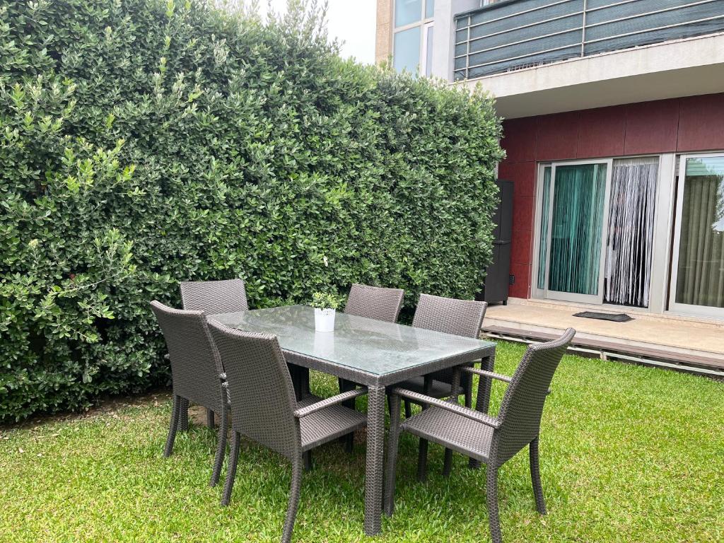 a table and chairs sitting on the grass at Vila Chã Beach House by Trip2Portugal in Vila Chã