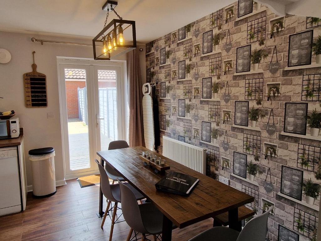 ein Esszimmer mit einem Holztisch und einer Wand mit Bildern in der Unterkunft Norwich, Lavender House, 3 Bedroom House, Private Parking and Garden in Norwich