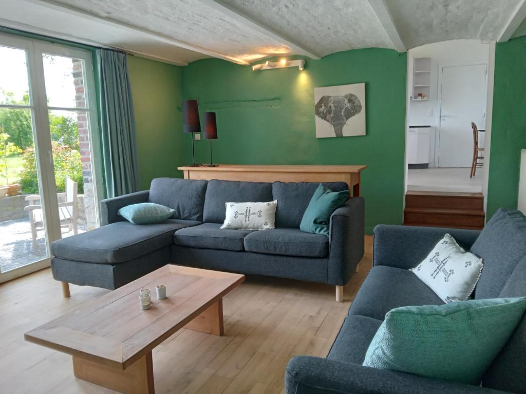 sala de estar con muebles azules y paredes verdes en Les 3 Bilobas en Héron