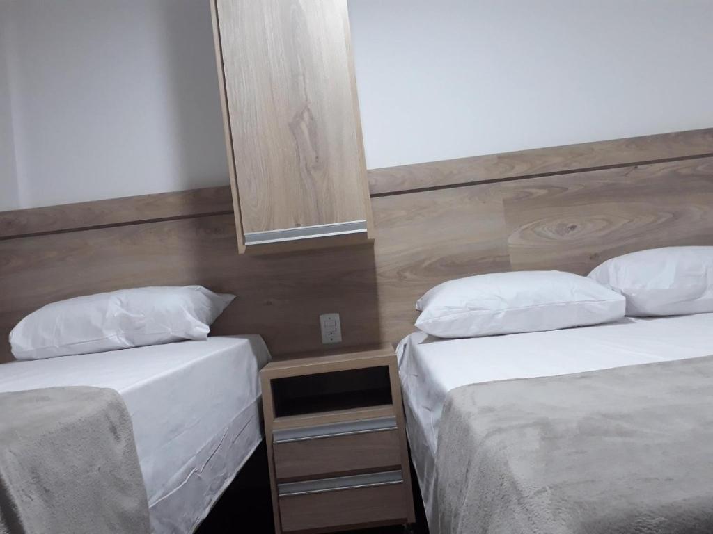 um quarto com duas camas e um espelho na parede em Hotel Wilson em Teixeiras