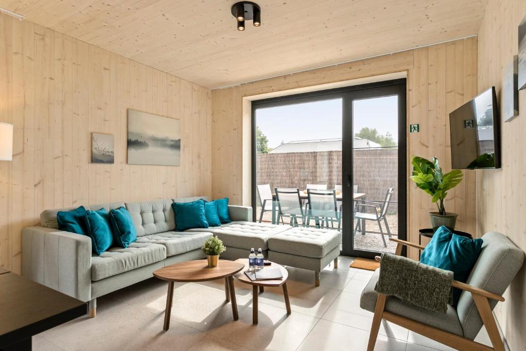 ein Wohnzimmer mit einem Sofa und einem Tisch in der Unterkunft Chalet Babette in Koksijde