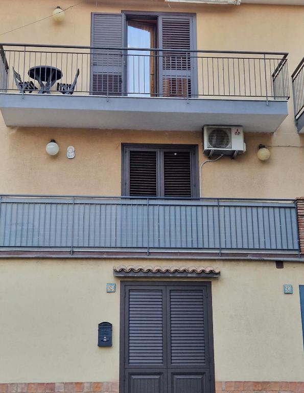 apartamentowiec z balkonem i drzwiami w obiekcie L'Isola e i Faraglioni house w mieście Aci Trezza