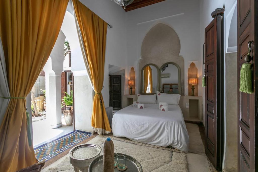 een slaapkamer met een bed en een groot raam bij Riad Safar in Marrakesh
