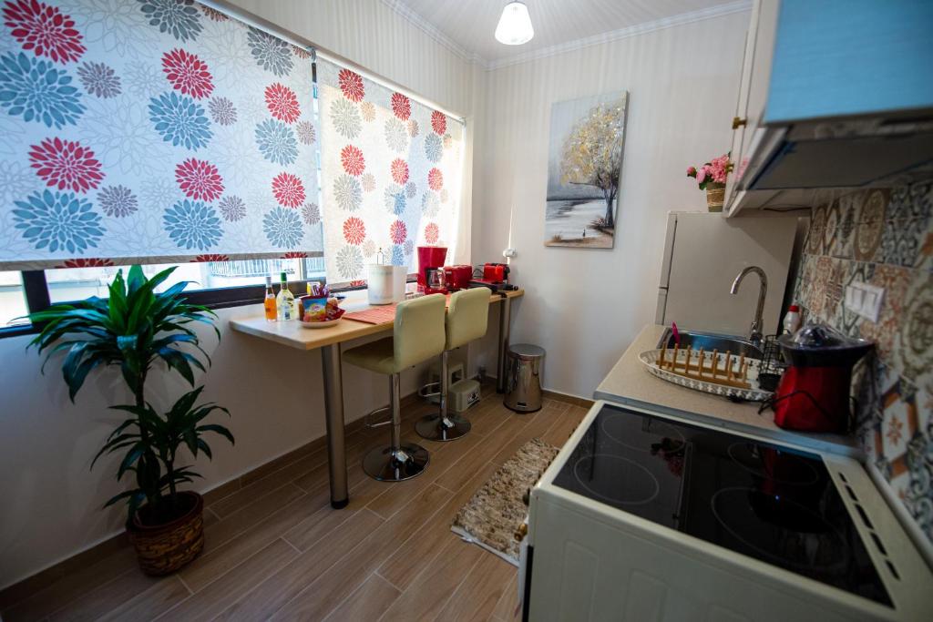 a small kitchen with a table and a refrigerator at Efie's Studio in Kalamata