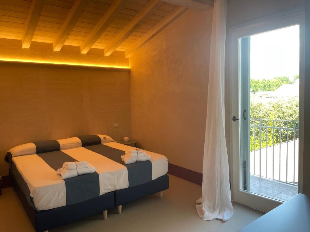a bedroom with two beds and a large window at LABottega - Camere in Marina di Pietrasanta