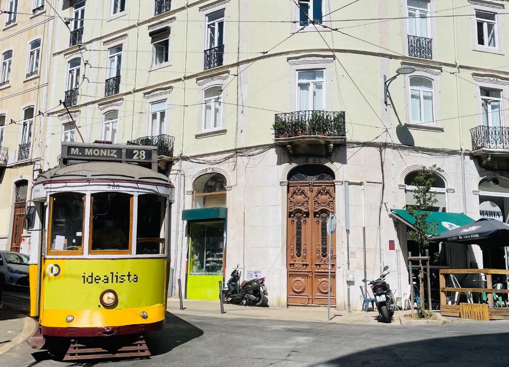 a yellow tram on a street in front of a building at Alojamento Local Private Accommodation in Lisbon
