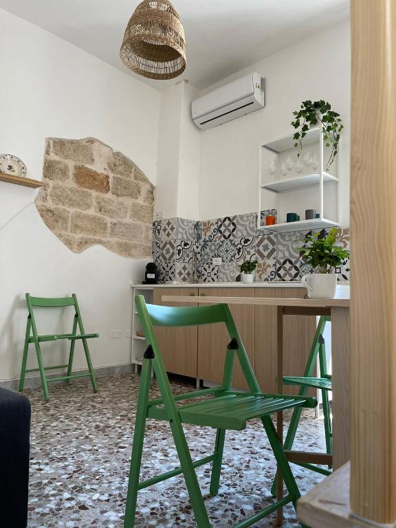 Pokój z biurkiem i 2 zielonymi krzesłami w obiekcie Dimora La Terrazza w mieście Polignano a Mare