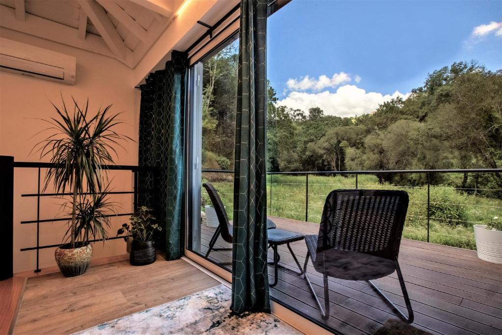 a patio with a chair and a balcony with a view at COUNTRY HOUSE by the RIVER - NATIONAL PARK in Arcos de Valdevez