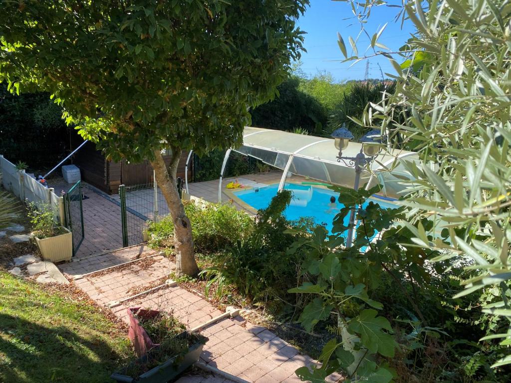a swimming pool in a yard with a tree at Proximité Biarritz - Arcangues in Arcangues