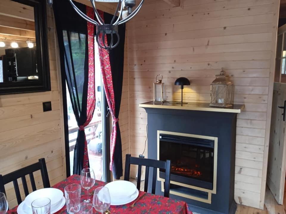 a dining room with a table and a fireplace at Domek na grapie in Gilowice