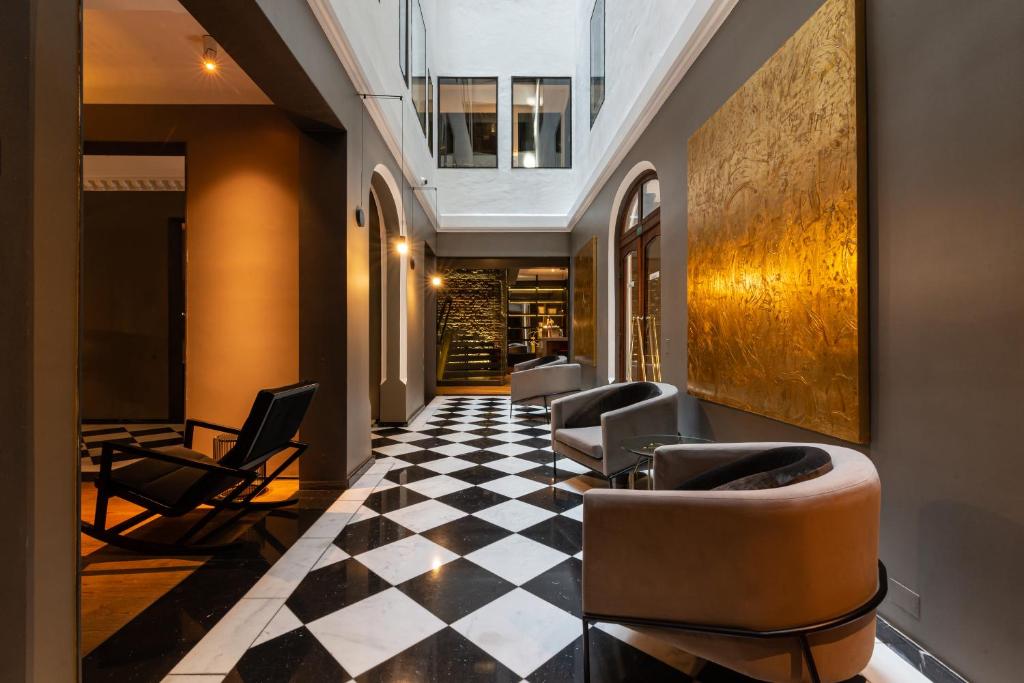 a lobby with chairs and a checkered floor at Hotel Magnolia Santiago in Santiago