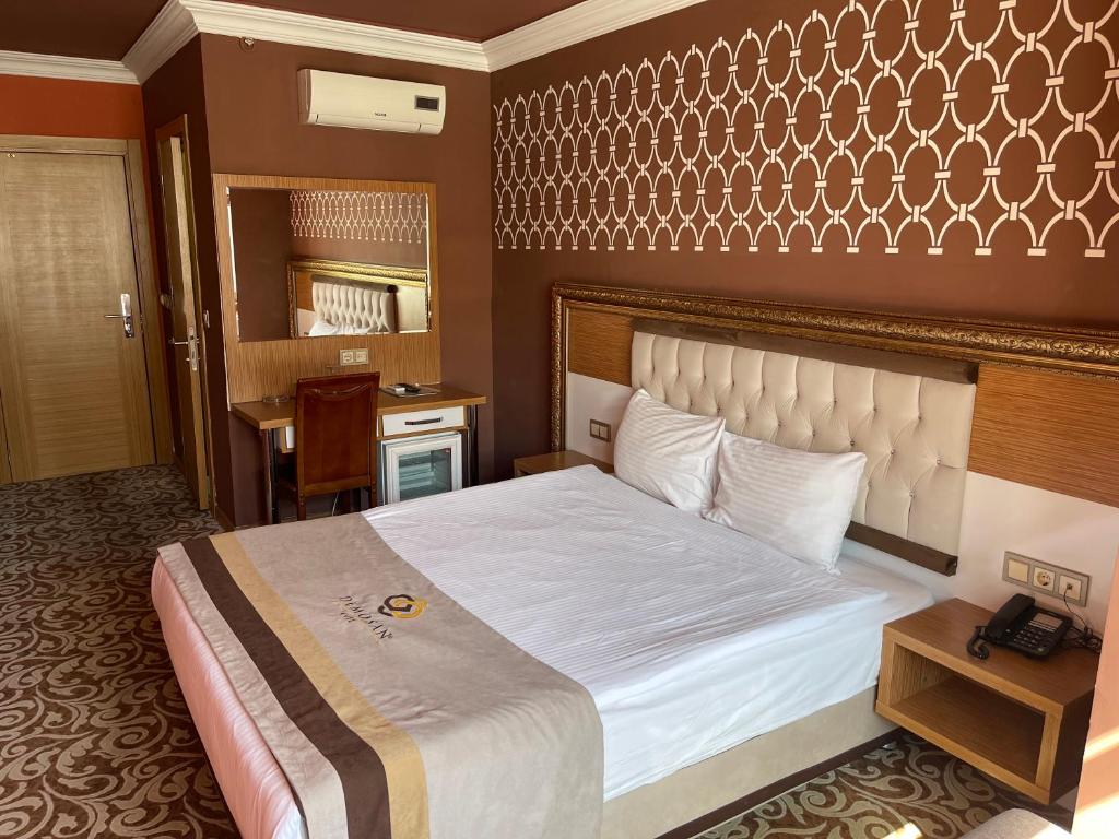 a hotel room with a large bed and a telephone at Demosan City Hotel in Konya