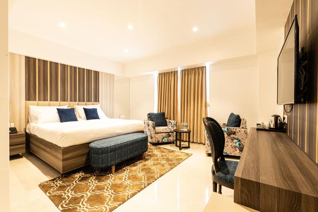 ein Hotelzimmer mit einem Bett und einem Wohnzimmer in der Unterkunft The Thane Club in Thane
