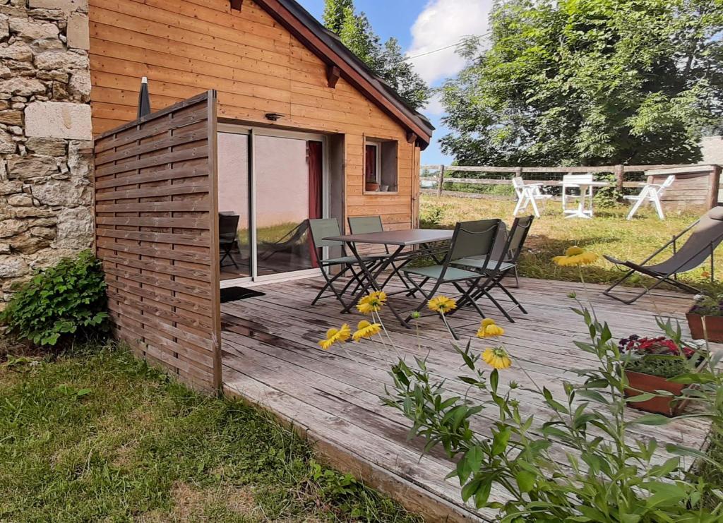 una terraza de madera con sillas y una mesa frente a una casa en Gîte Toukoul, en Autrans