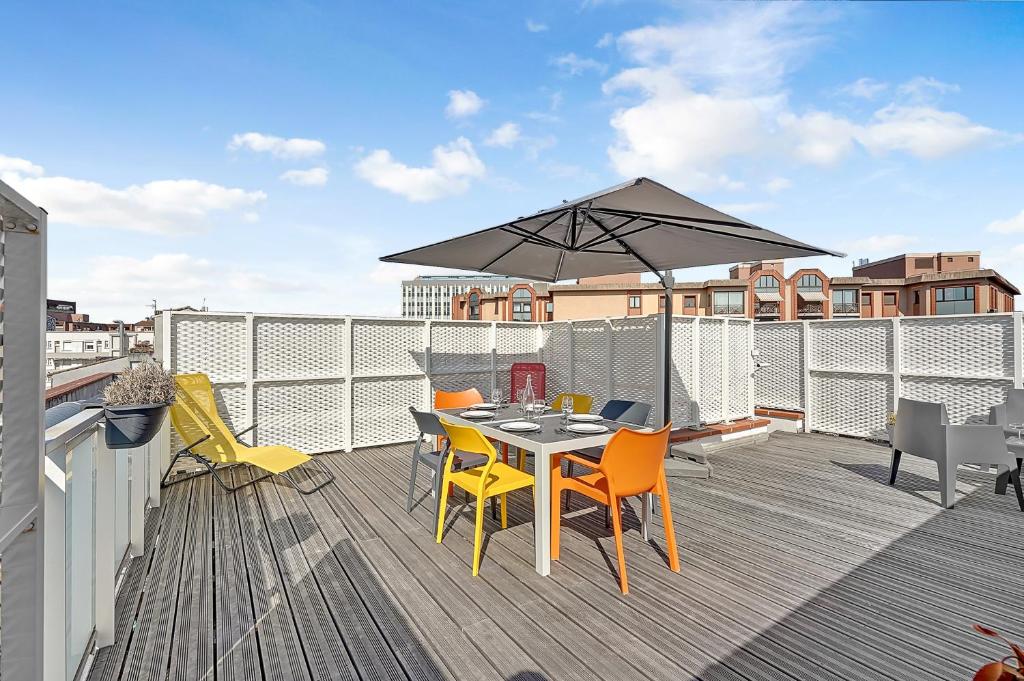 a patio with a table and chairs and an umbrella at Le Patio Guilhemery in Toulouse