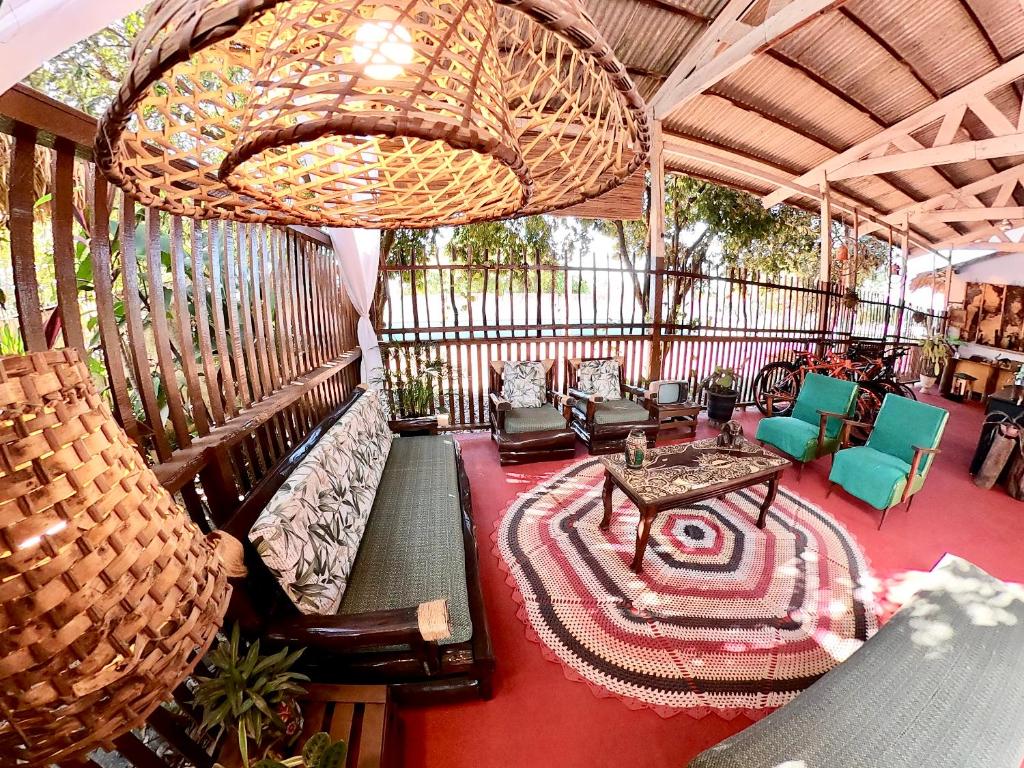 eine Veranda mit Sofas, Stühlen und einem Kronleuchter in der Unterkunft Pousada Ocazum in Alter do Chao