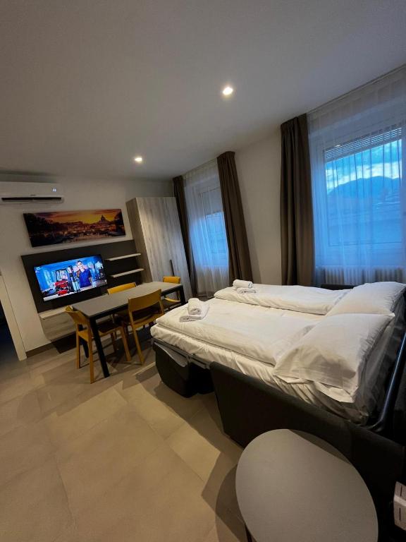 sypialnia z łóżkiem, stołem i telewizorem w obiekcie Bilo - Apartments for rent w Trydencie