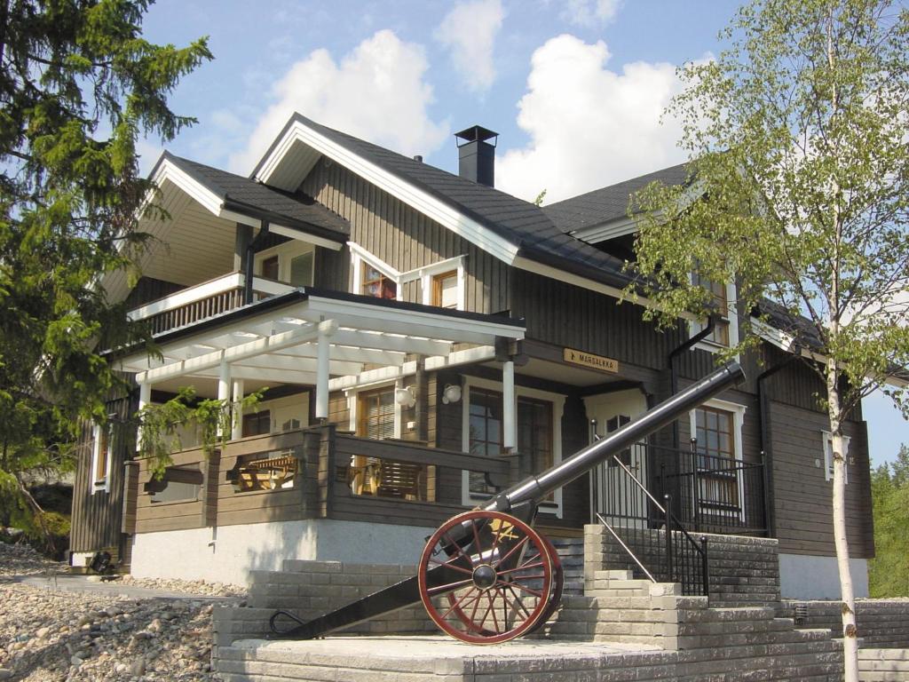 a house with a cannon in front of it at Vuokatin Aateli Villa Marsalkka in Vuokatti