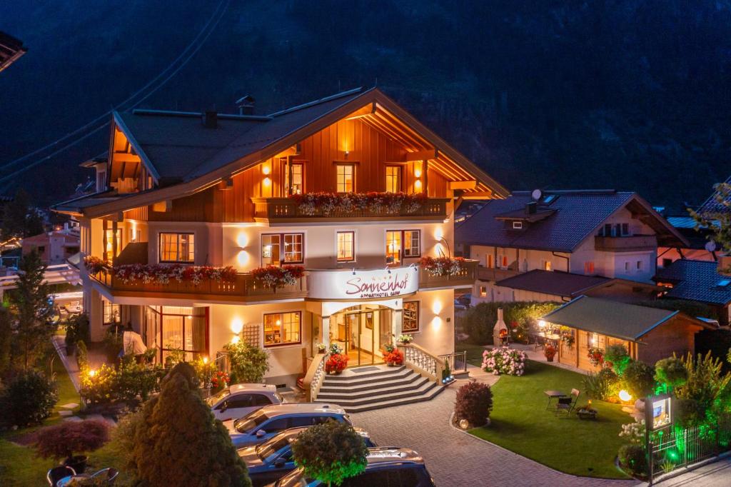 a large building with cars parked in front of it at Apparthotel Sonnenhof in Mayrhofen