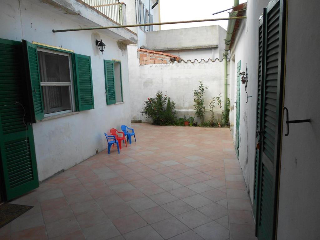einen Innenhof mit zwei blauen Stühlen und einem Gebäude in der Unterkunft La Lantana in San Vito
