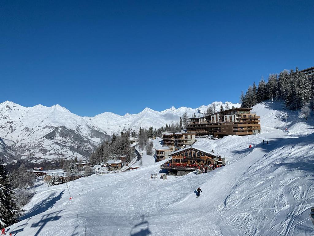 a person skiing down a snow covered ski slope at LE RIDGE nouvelle résidence prestige - Les Arcs Paradiski in Bourg-Saint-Maurice