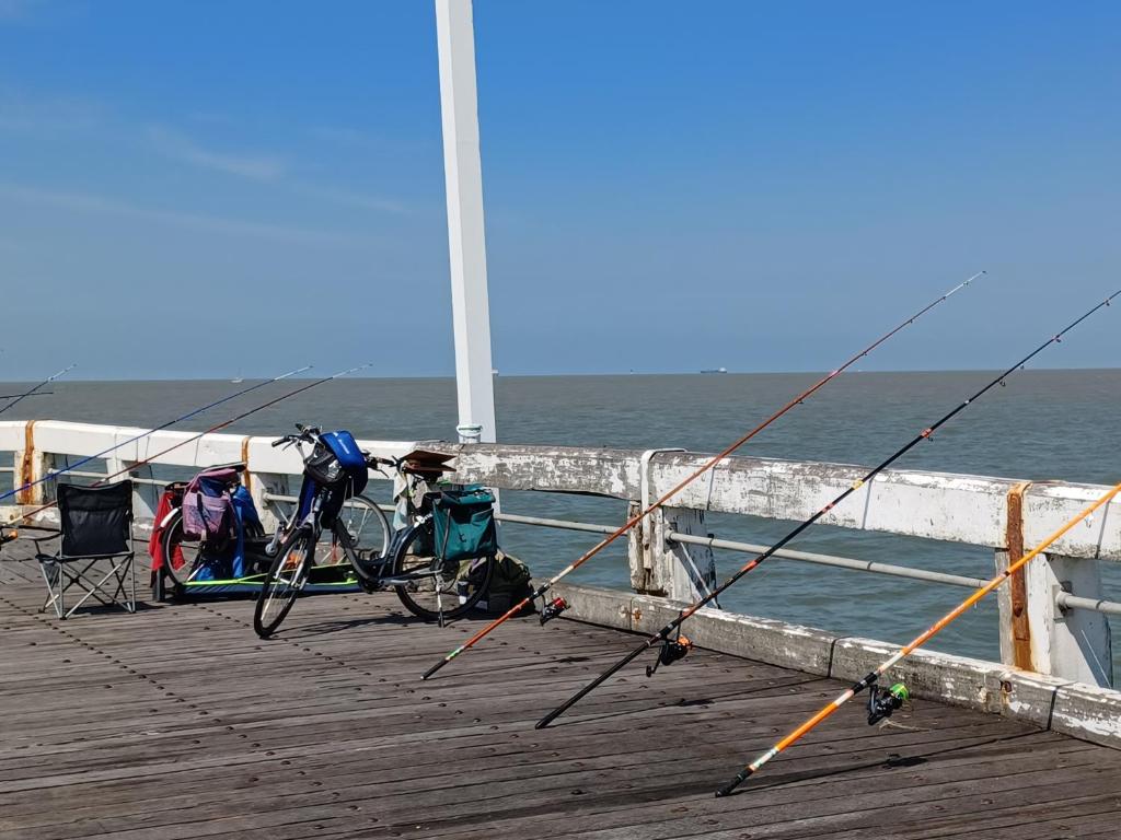 a pier with two bikes and a pole on the water at Appartement Blankenberge Zeedijk aan de Pier in Blankenberge