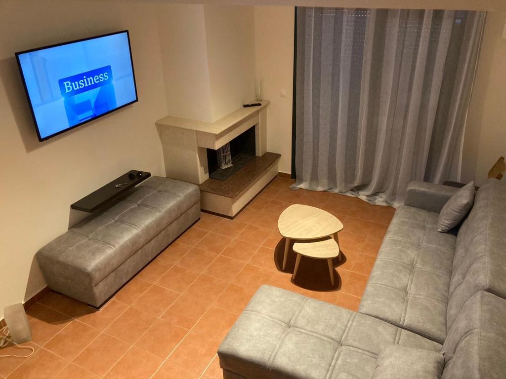 a living room with a couch and a tv at enJOY Golden beach in Skala Potamias