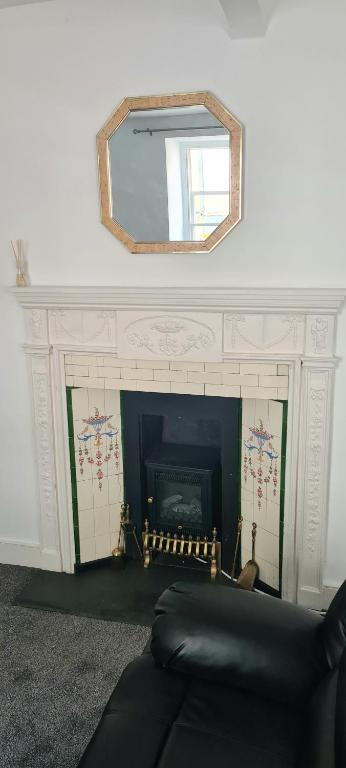 a living room with a fireplace and a mirror at Fore Street Bodmin in Bodmin