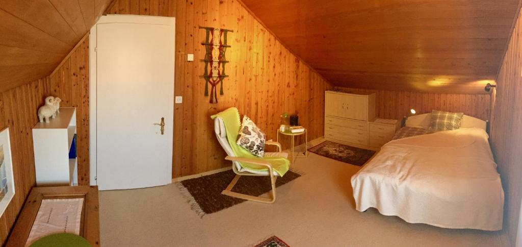 ein Schlafzimmer mit einem Bett und einem Stuhl in einem Zimmer in der Unterkunft Silvia's Bed und Breakfast in Luzern in Luzern