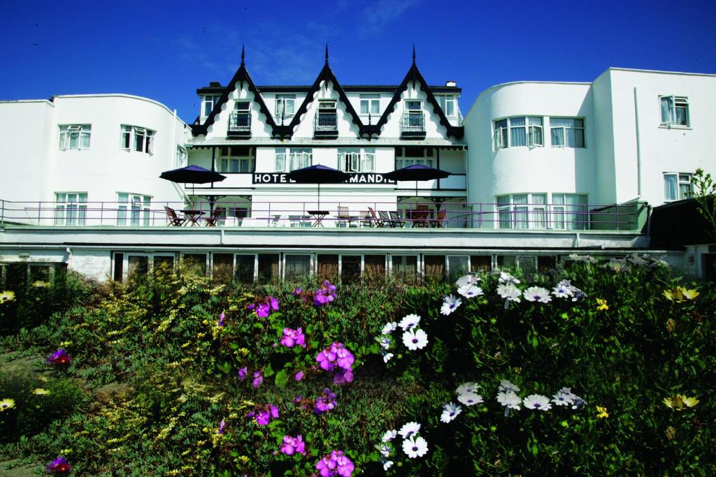 a hotel with tables and flowers in front of it at Hotel De Normandie in Saint Helier Jersey