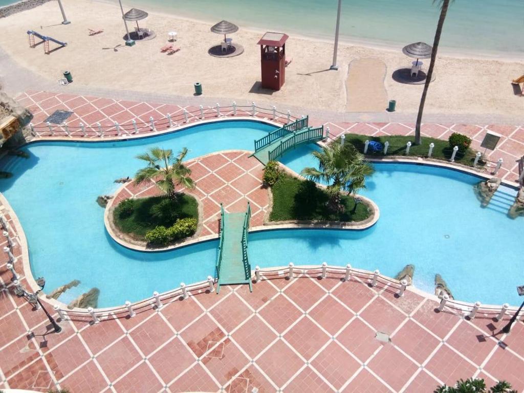 een uitzicht over het zwembad van een resort bij Durrah Beach Apartment in Durat Alarous