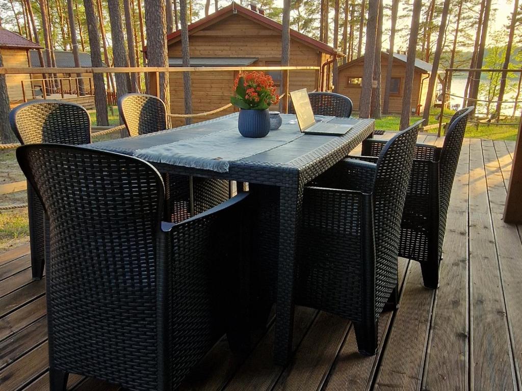 una mesa con sillas y un ordenador portátil en el patio en Oslo N°29 Domek Letniskowy, en Borsk