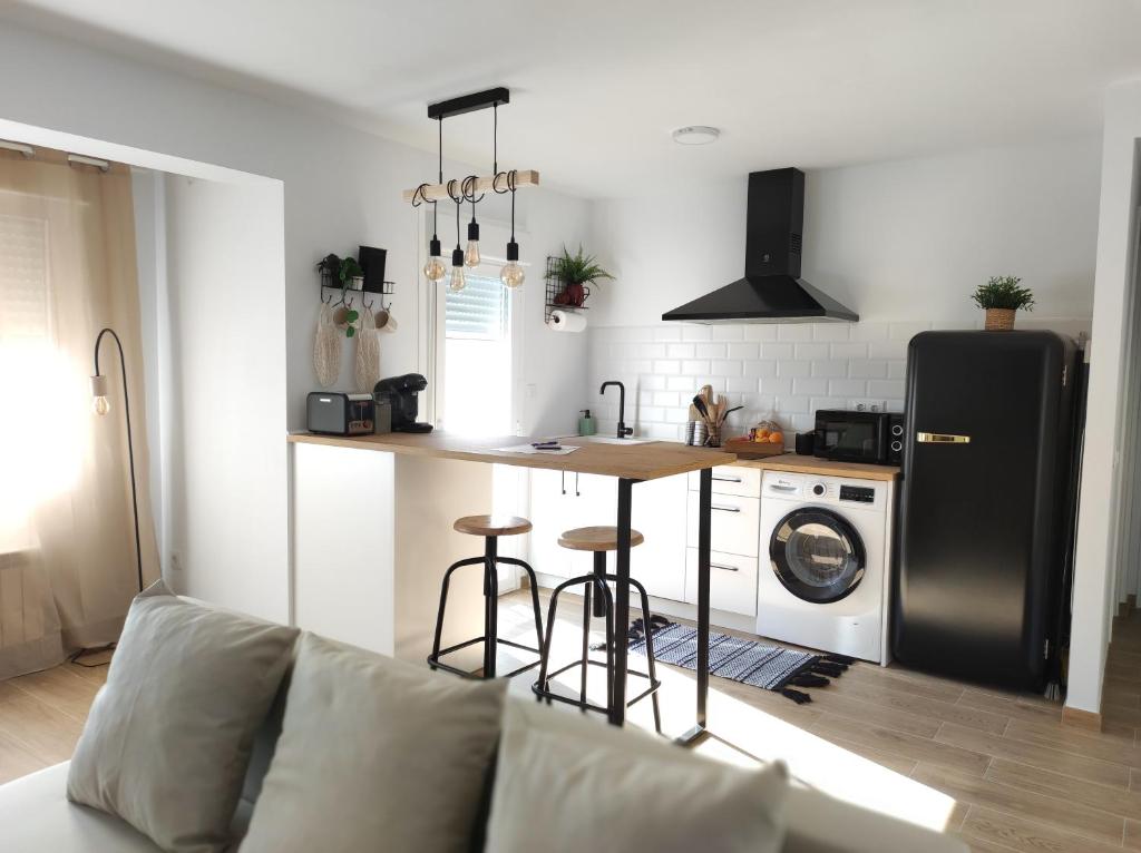 a kitchen with a refrigerator and a table and a stove at Apartamentos La Casa del Maestro in Alhama de Aragón
