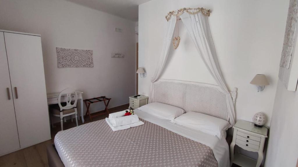 1 dormitorio con 1 cama blanca con dosel en BeB Pignatelli Affittacamere, en Matera