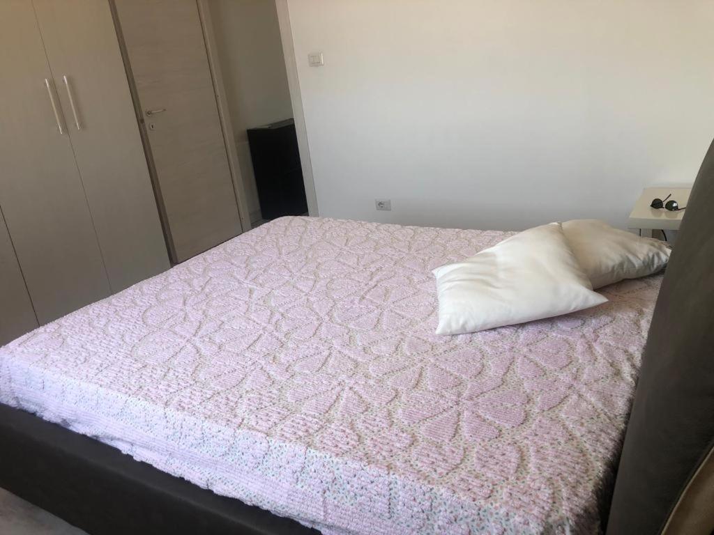 1 dormitorio con cama rosa y almohada en Beach house, en Villaggio San Leonardo