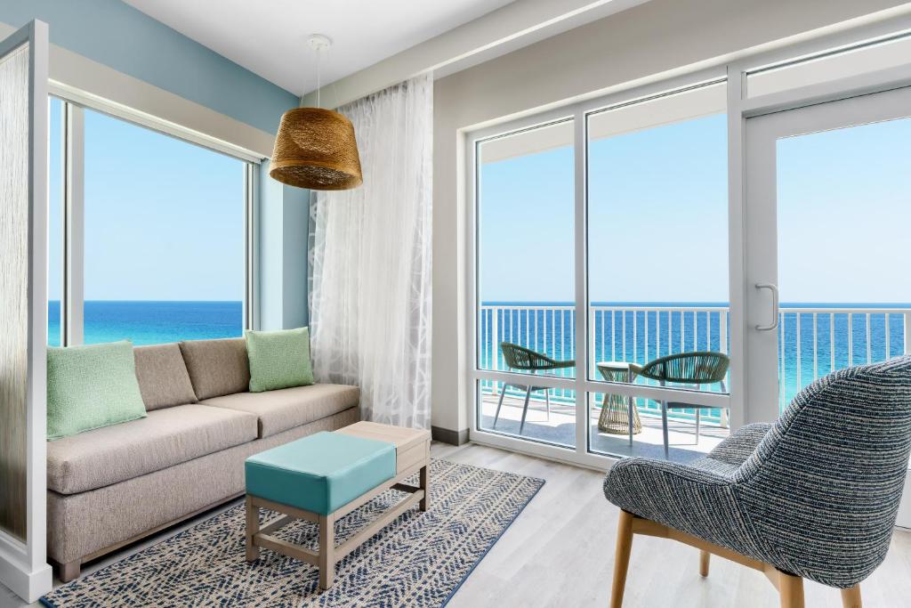 a living room with a couch and a view of the ocean at Hyatt Place Panama City Beach - Beachfront in Panama City Beach