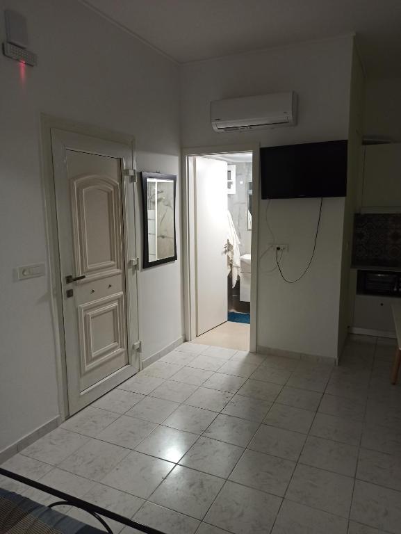 a room with a hallway with a door and a tv at Christos beach apart in Kos Town