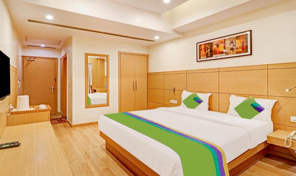 a bedroom with a large bed and a television at Treebo Trend Galaxy Rooms in New Delhi