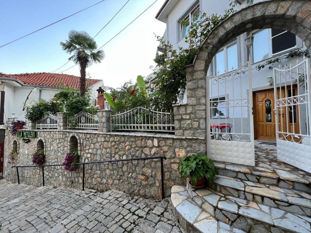 a house with a stone wall and a fence at Villa Metulevi in Ohrid