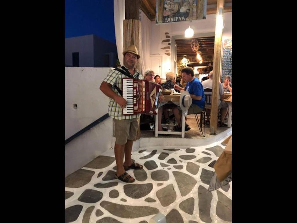 mężczyzna trzyma akordeon w restauracji w obiekcie Studio Seagull - By Old Market Street - Naxos Town w mieście Naksos