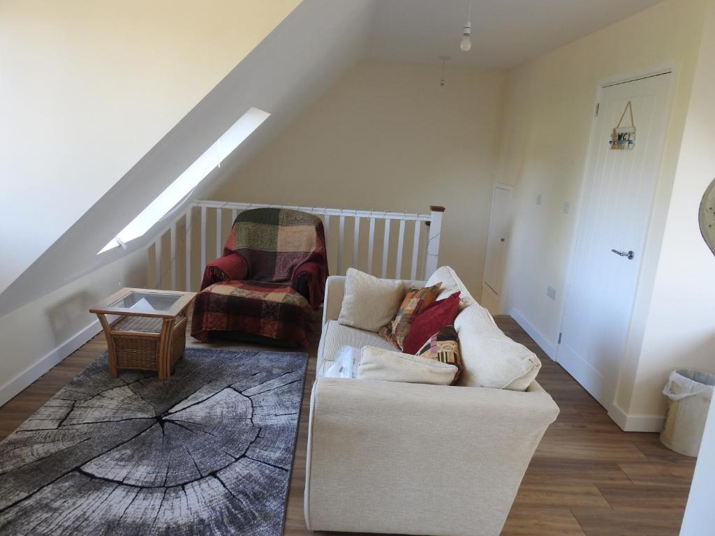 a living room with a white couch and a chair at The Shed @ Stares Farm Cottage in Shedfield