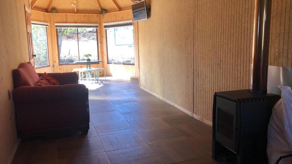 a living room with a couch and a television at Cabaña Recinto Valle Las Trancas in Recinto