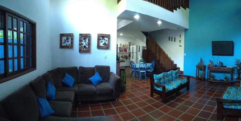 a living room with a couch and a table at Casa Azul in Caraguatatuba