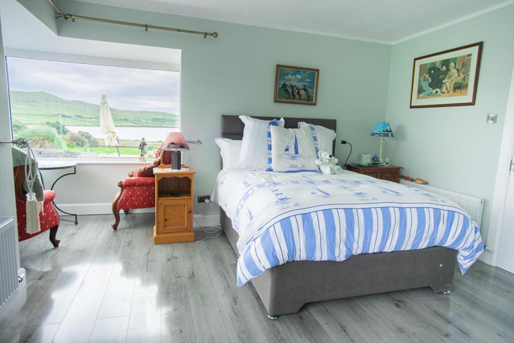 a bedroom with a bed and a large window at Half Door House in Dingle